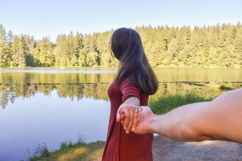 couple holding hands while hiking
